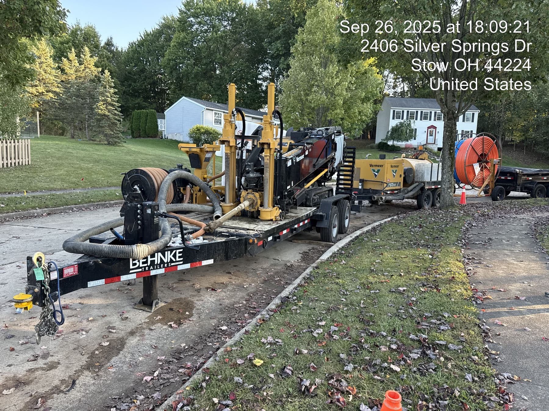 Directional drill on a trailer with a vacuum excavator and conduit reel set up along a curb in Stow, Ohio